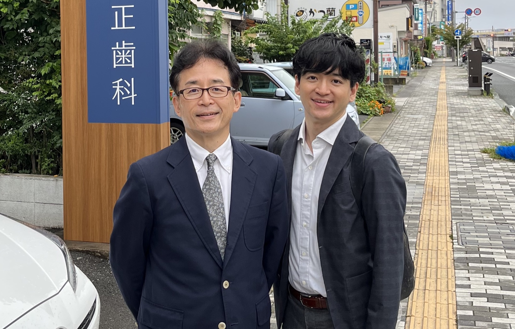 父と、医院の看板の前で